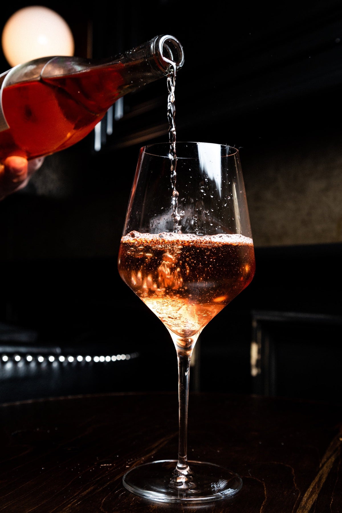 Orange Wein wird ins Glas eingeschenkt